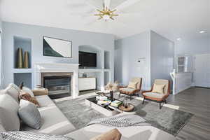 Living area featuring wood finished floors, ceiling fan, built in features, a fireplace, and recessed lighting