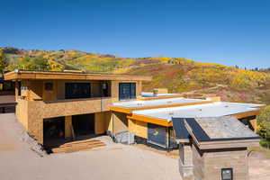 View of front of property with stucco siding, a balcony, and a mountain view