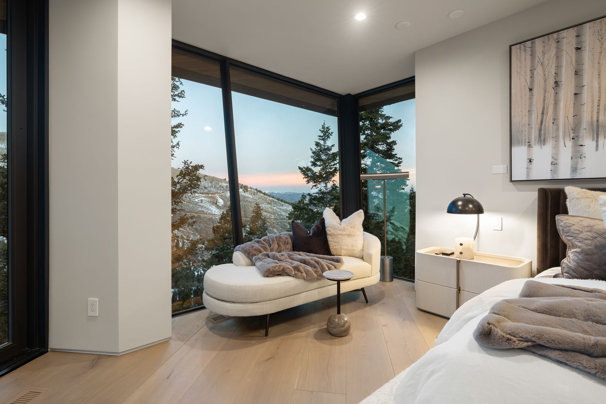 Bedroom with expansive windows, light wood-style floors, and a mountain view
