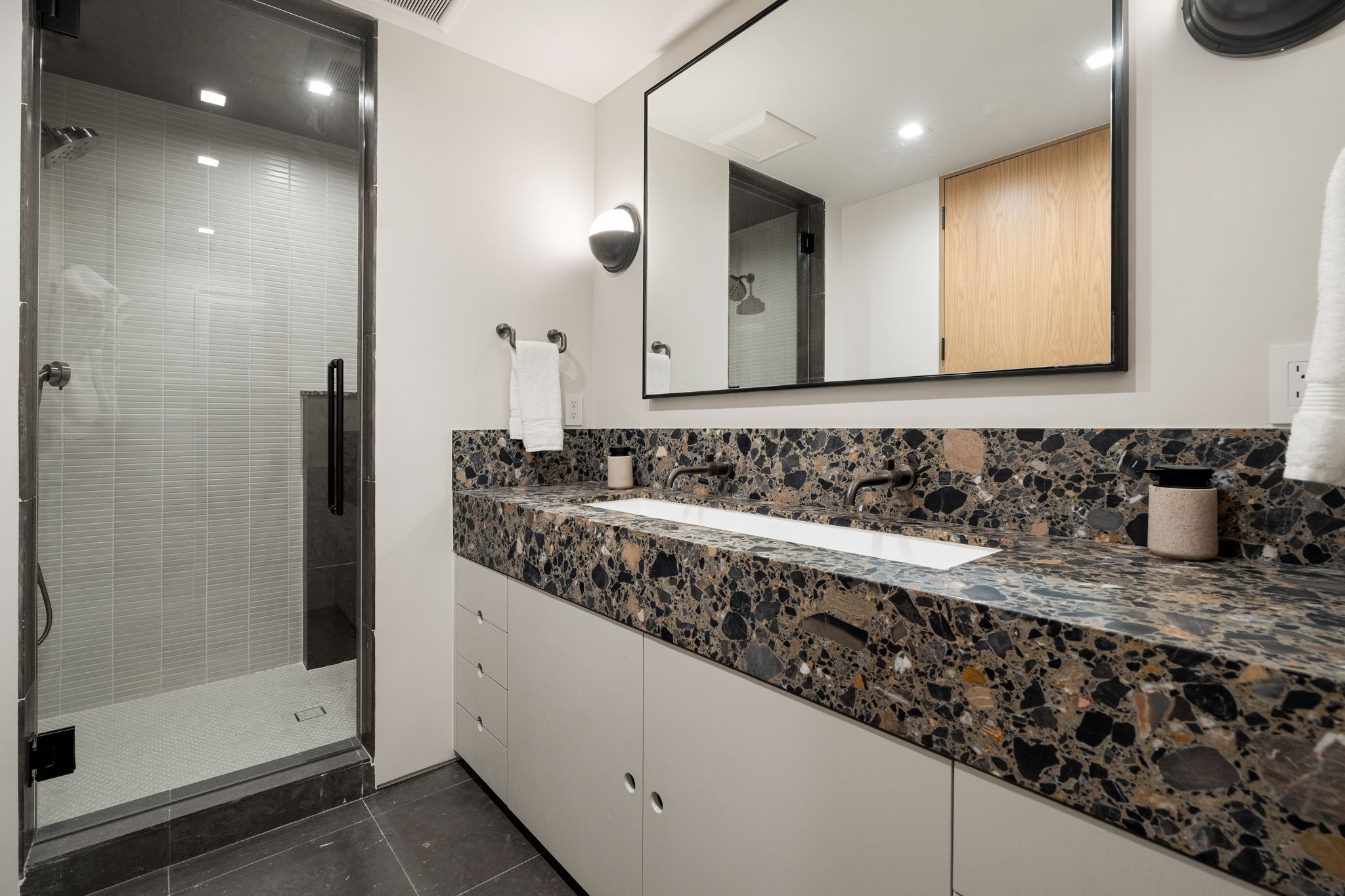 Bathroom featuring a stall shower, vanity, dark tile patterned floors, and recessed lighting