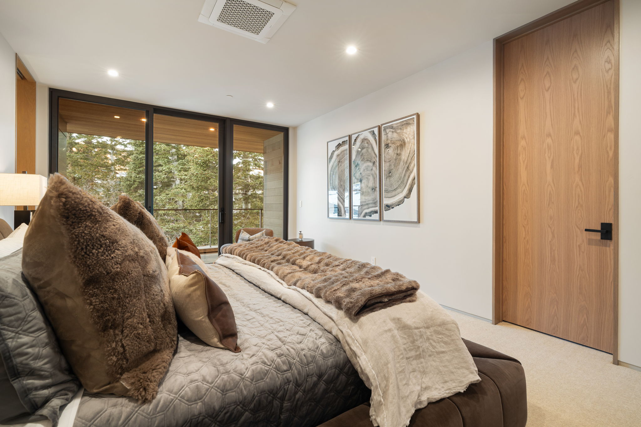Bedroom with light carpet, recessed lighting, and floor to ceiling windows