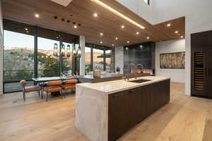 Kitchen featuring a mountain view, dark wood finish cabinetry, modern cabinets, light wood-style floors, and light stone countertops