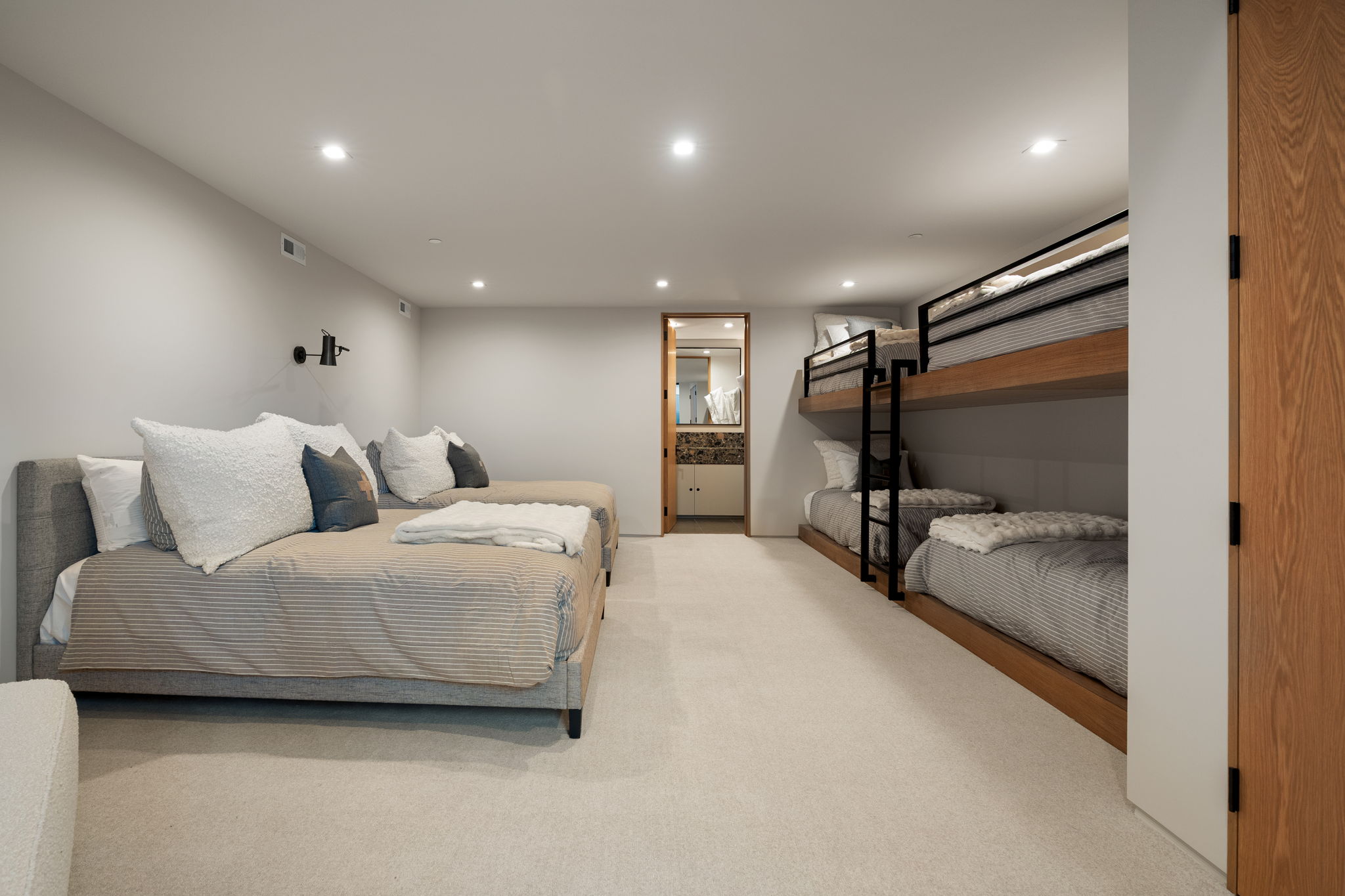 Bedroom with recessed lighting, light colored carpet, and ensuite bath