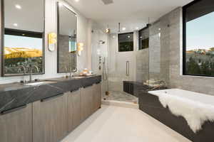 Bathroom featuring double vanity, a stall shower, a garden tub, and recessed lighting