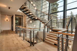 Staircase featuring hardwood / wood-style floors, expansive windows, and a towering ceiling