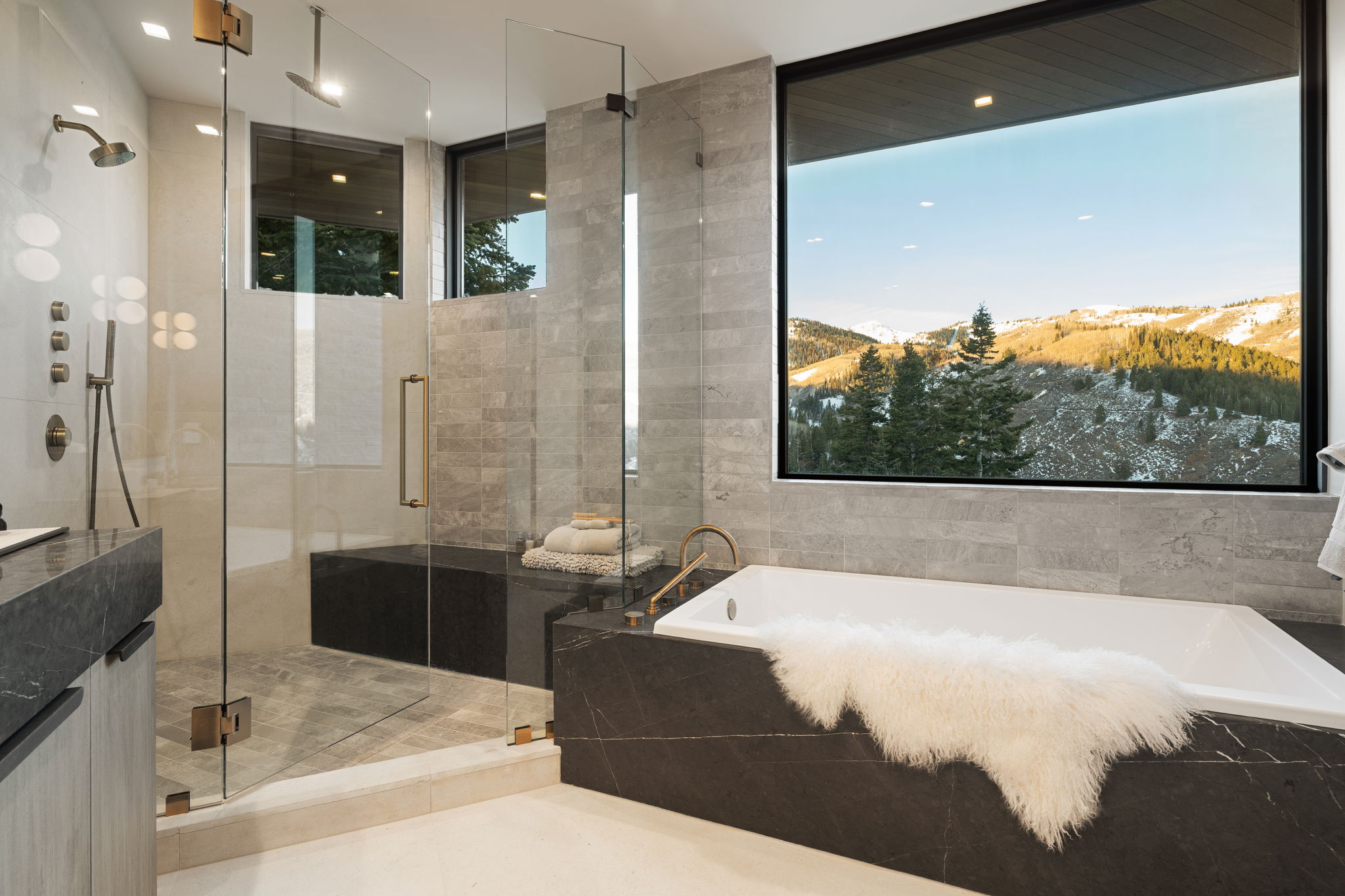 Bathroom with a mountain view, a shower stall, a bath, vanity, and tile walls