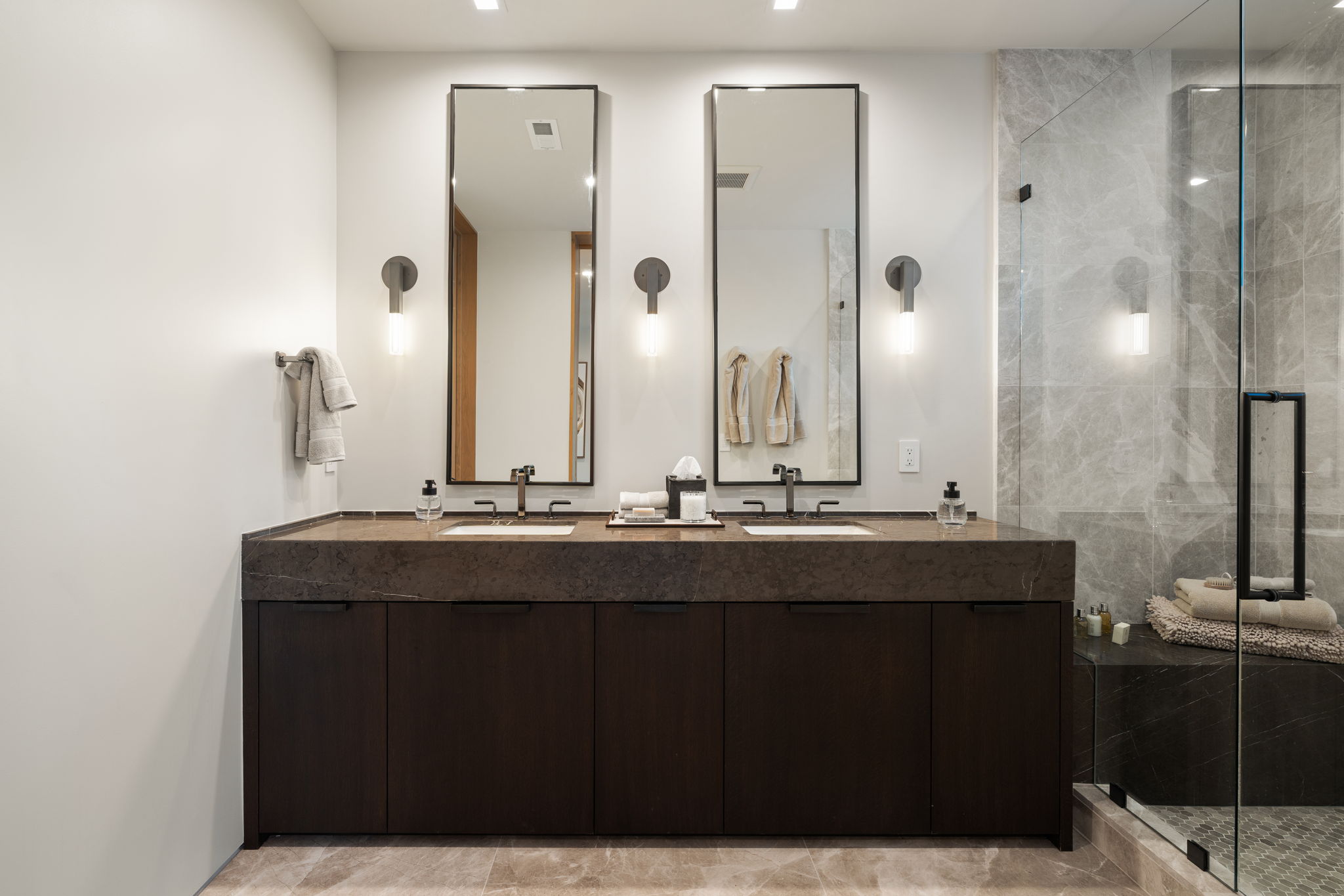 Full bathroom featuring a marble finish shower, double vanity, and recessed lighting