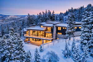 Snow covered house with a balcony and a chimney