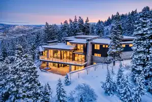 Snow covered house with a balcony and a chimney