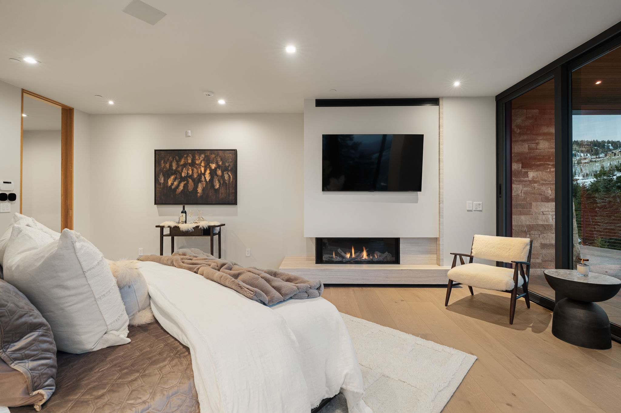 Living room featuring light wood finished floors, a glass covered fireplace, recessed lighting, and expansive windows