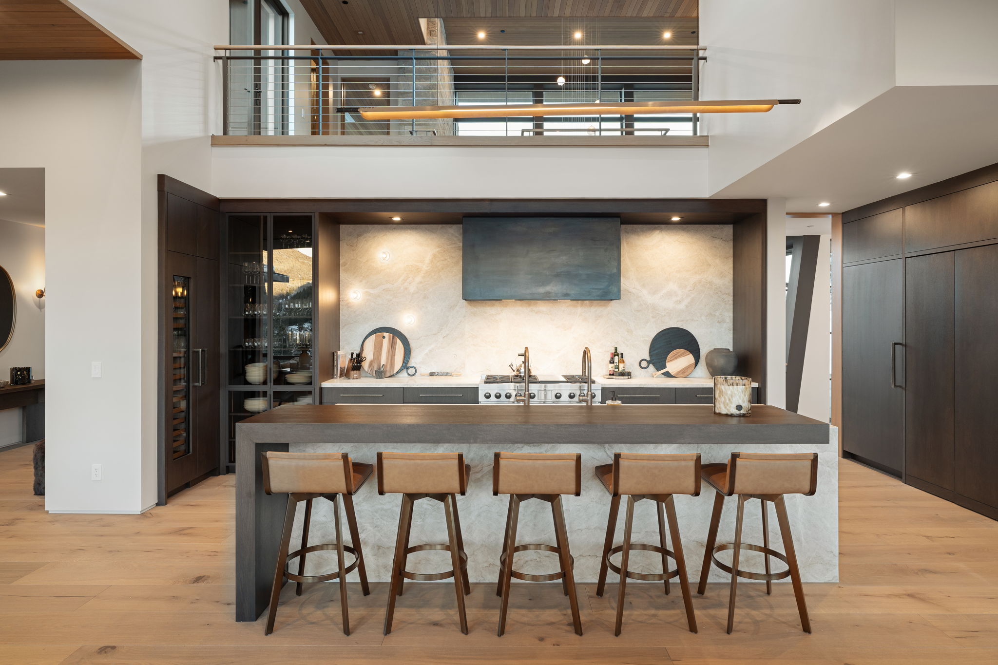Kitchen featuring a high ceiling, a kitchen bar, light wood-style floors, recessed lighting, and butcher block counters