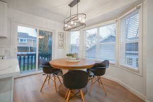 Dining space featuring a chandelier, light wood-type flooring, and healthy amount of natural light