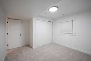 Unfurnished bedroom featuring light colored carpet and a closet