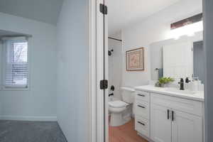 Bathroom featuring vanity, shower / washtub combination, and light wood finished floors