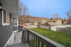 Wooden terrace with a residential view, a fenced backyard, and a mountain view