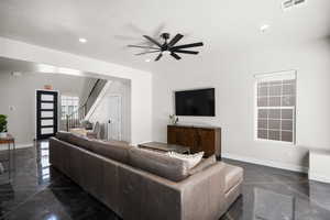 Living room featuring stairs, a ceiling fan, and recessed lighting