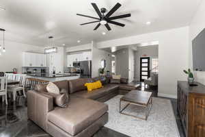 Living room featuring ceiling fan, stairway, and recessed lighting