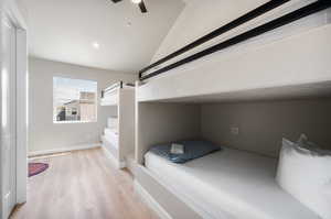 Unfurnished bedroom featuring light wood-style floors, a ceiling fan, lofted ceiling, and recessed lighting