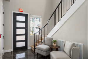 Foyer with stairway and a towering ceiling