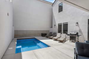Back of house with a patio, stucco siding, and an outdoor pool