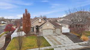 Traditional home with stucco siding, concrete driveway, a residential view, stone siding, and roof with shingles