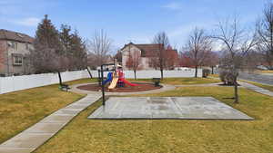 View of community with a fenced backyard and community basketball court