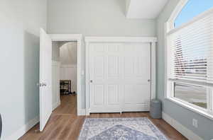 Unfurnished bedroom featuring a closet, wood finished floors, and arched walkways