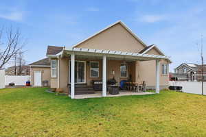 Rear view of property featuring stucco siding, a patio area, and a shingled roof