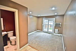 Half bathroom with vanity, light carpet, and recessed lighting