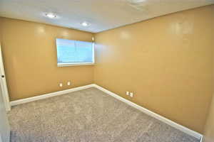 Carpeted spare room with recessed lighting and a textured ceiling