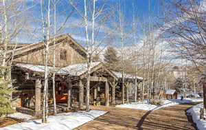View of front facade featuring covered porch and stone siding