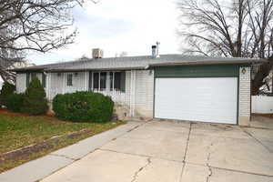 Single story home featuring driveway, a garage, brick siding, and roof with shingles