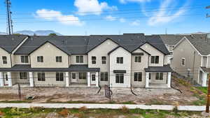 Rear view of property featuring a patio area, stucco siding, brick siding, and a mountain view