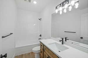 Bathroom with shower / bath combination, vanity, and light wood-style floors