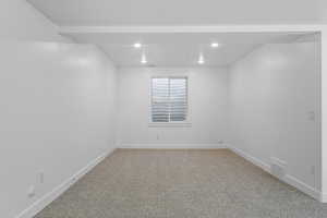 Carpeted spare room with baseboards and recessed lighting