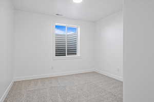 Unfurnished room featuring light carpet and baseboards