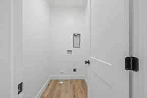 Laundry area with gas dryer hookup, light wood-type flooring, and washer hookup