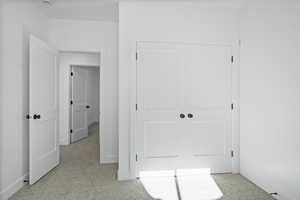 Unfurnished bedroom featuring light carpet and a closet