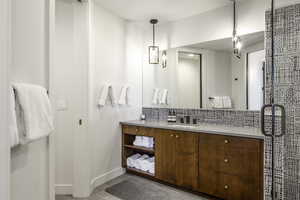 Full bathroom with vanity, tasteful backsplash, and a shower stall