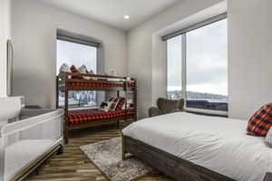Bedroom featuring dark wood-type flooring, multiple windows, and recessed lighting