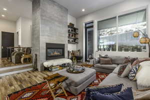 Living room featuring a tile fireplace, wood finished floors, and recessed lighting