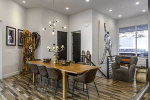 Dining space with wood finished floors, a chandelier, and recessed lighting