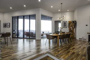 Dining area with recessed lighting, dark wood-style floors, healthy amount of natural light, and a chandelier