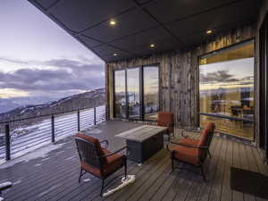Snow covered deck featuring a mountain view