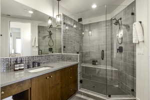 Full bath with vanity, a shower stall, recessed lighting, and decorative backsplash