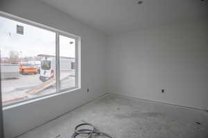 Spare room featuring unfinished concrete floors