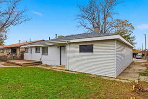 Back of house with a lawn, a chimney, and a wooden deck