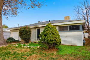 View of front facade featuring a chimney and a sunroom