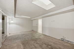 Carpeted empty room featuring a textured ceiling
