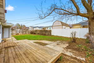 Wooden terrace featuring a patio area and a fenced backyard